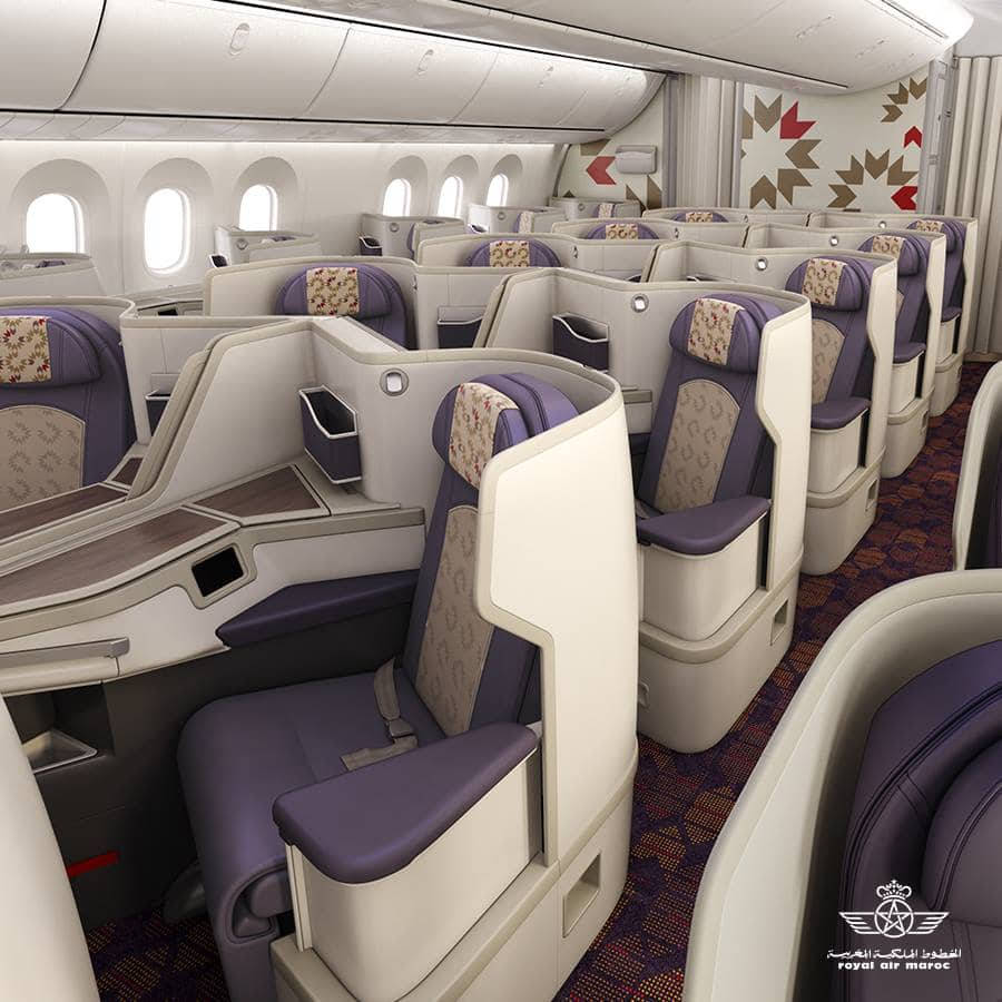 皇家摩洛哥航空高級飛機艙 壁紙 — 豪華飛機商務艙，配有紫色軟墊座椅和圖案地毯。