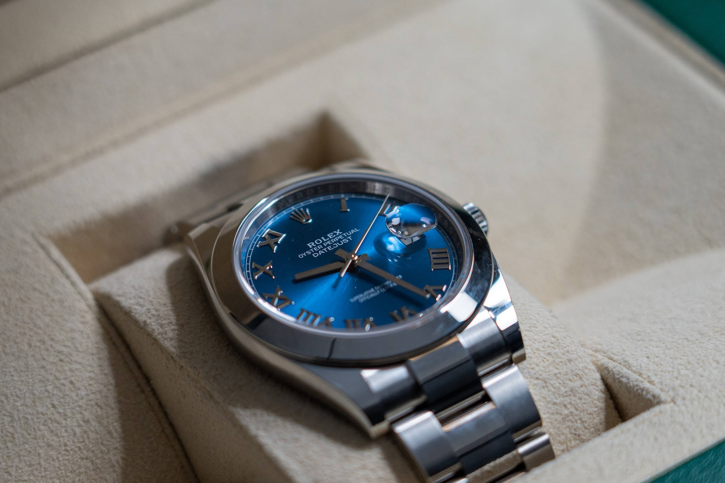 皇家藍色內飾勞力士 壁紙 — 一隻奢華的勞力士Oyster Perpetual，配以充滿活力的藍色錶盤，優雅地安放在其奶油色的展示盒中。