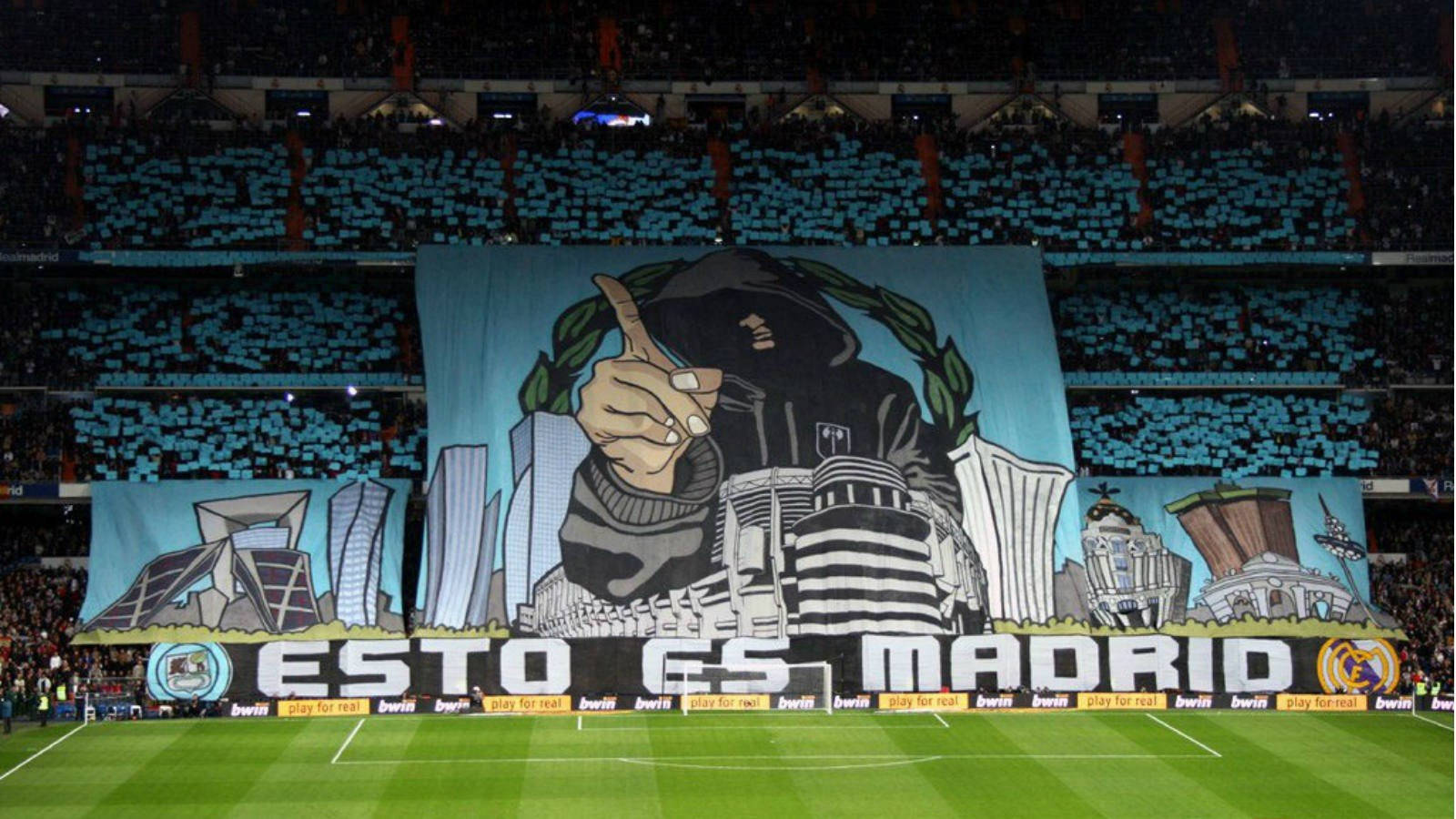 大型足球球迷橫幅，上面寫著「ESTO ES MADRID」，在一個有藍色座位的體育場內。