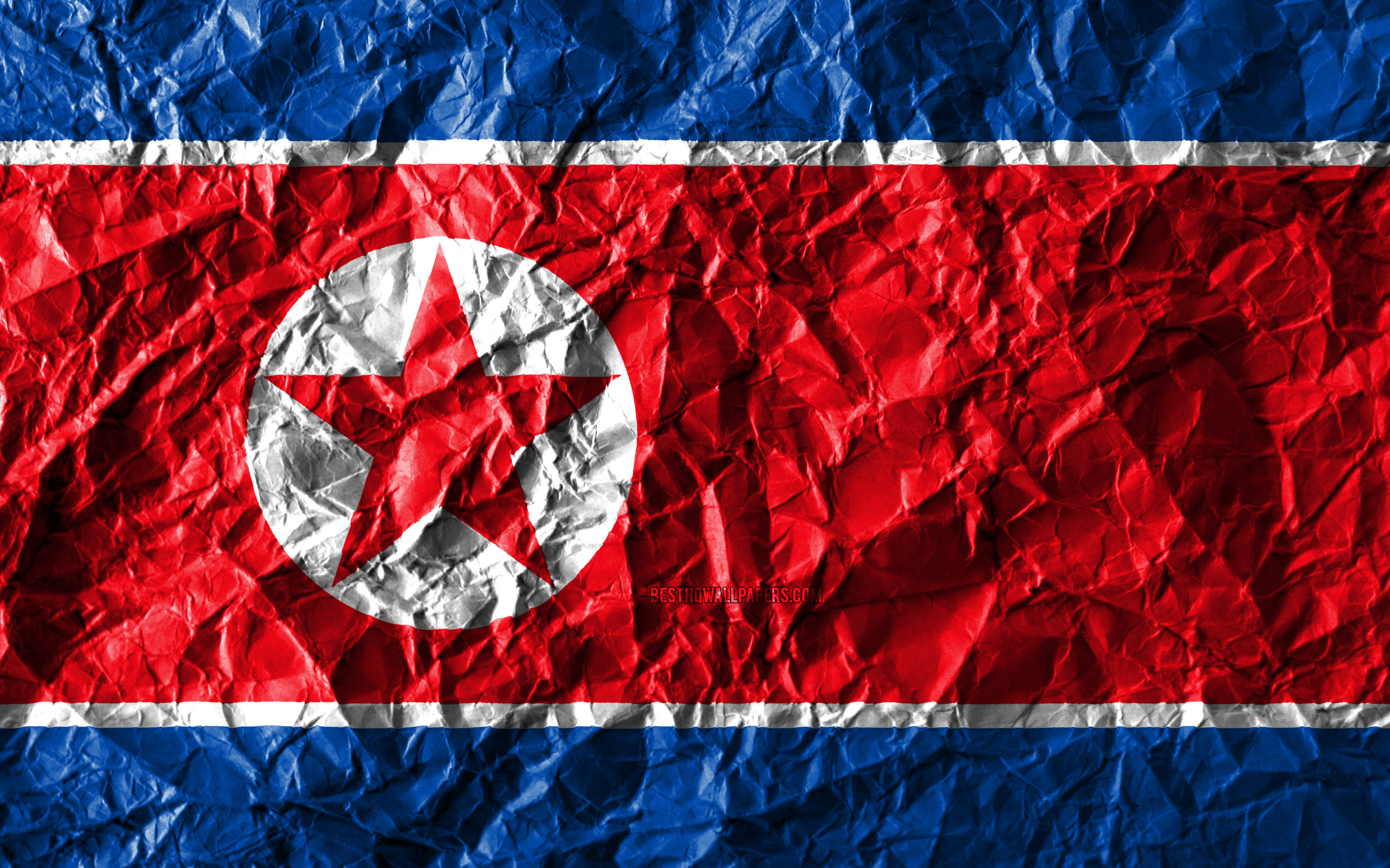 North Korea 桌布 壁紙 — 皺巴巴的北韓國旗，帶有紅、白、藍條紋和白色圓圈內的紅星。