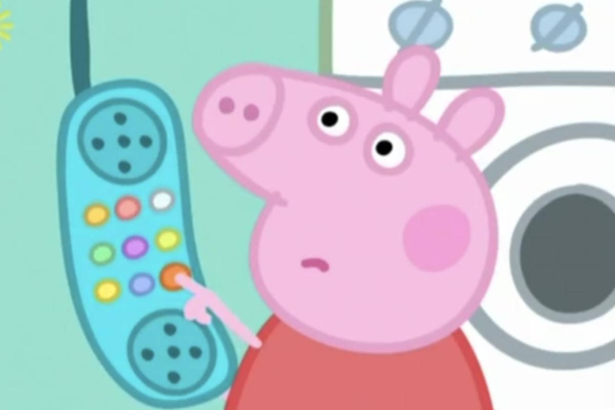 Peppa Pig 拿著彩色玩具電話並按下按鈕。