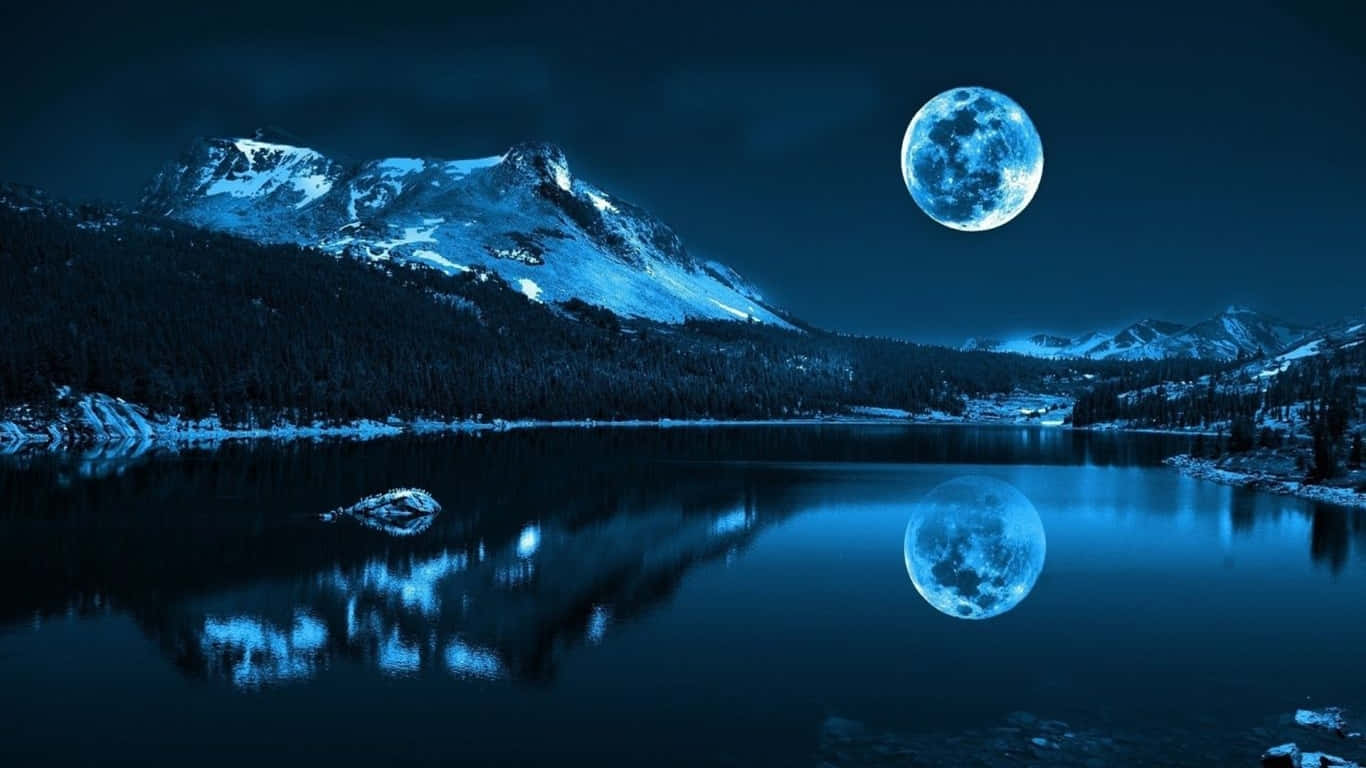 寧靜的湖面在深藍色夜空下映照出滿月和積雪的山脈。