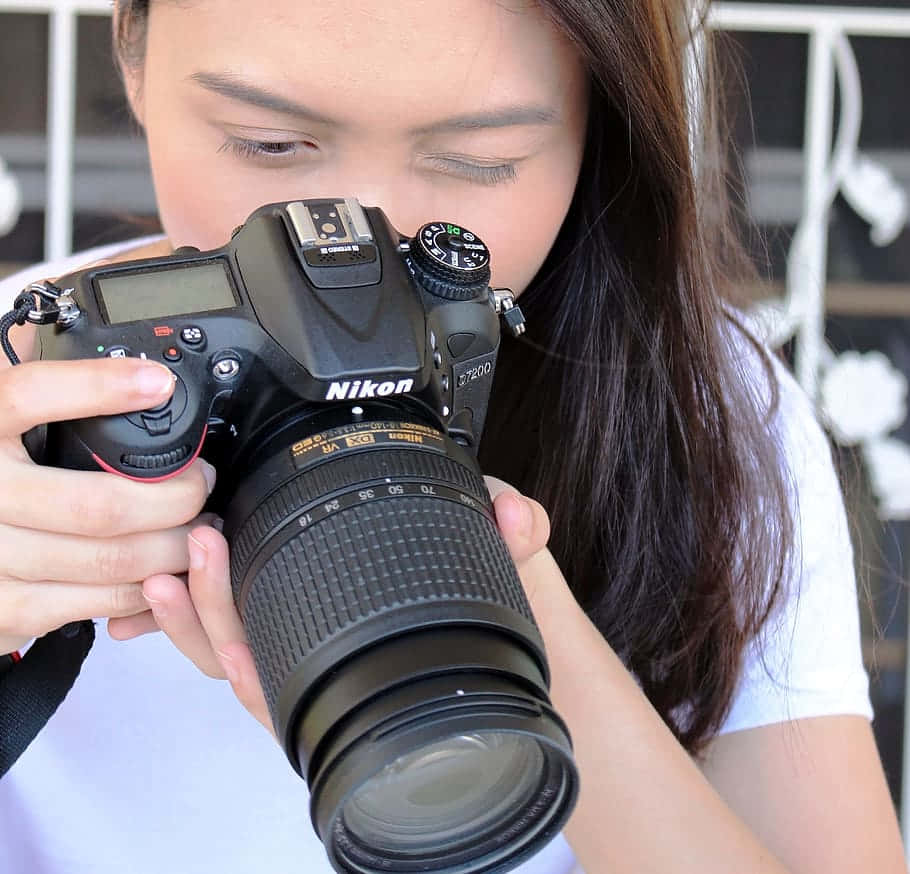 年輕女性手持Nikon DSLR相機進行攝影