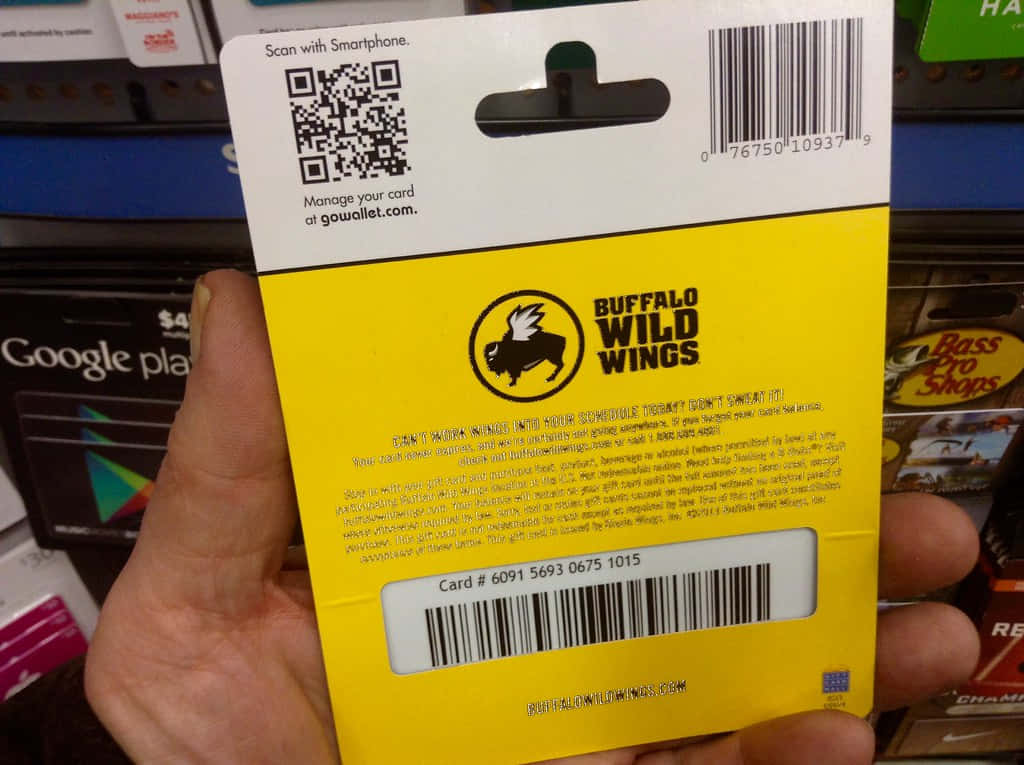 手拿著一張Buffalo Wild Wings禮品卡背面，上面有條碼和標誌。