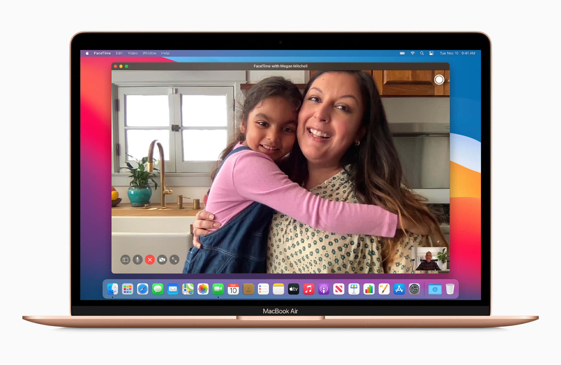 盡享MacBook絢麗的Retina顯示屏 壁紙 — 一部金色 MacBook Air 顯示一個溫暖的 FaceTime 通話，畫面中一位微笑的女士和一個孩子在陽光明媚的廚房裡擁抱。