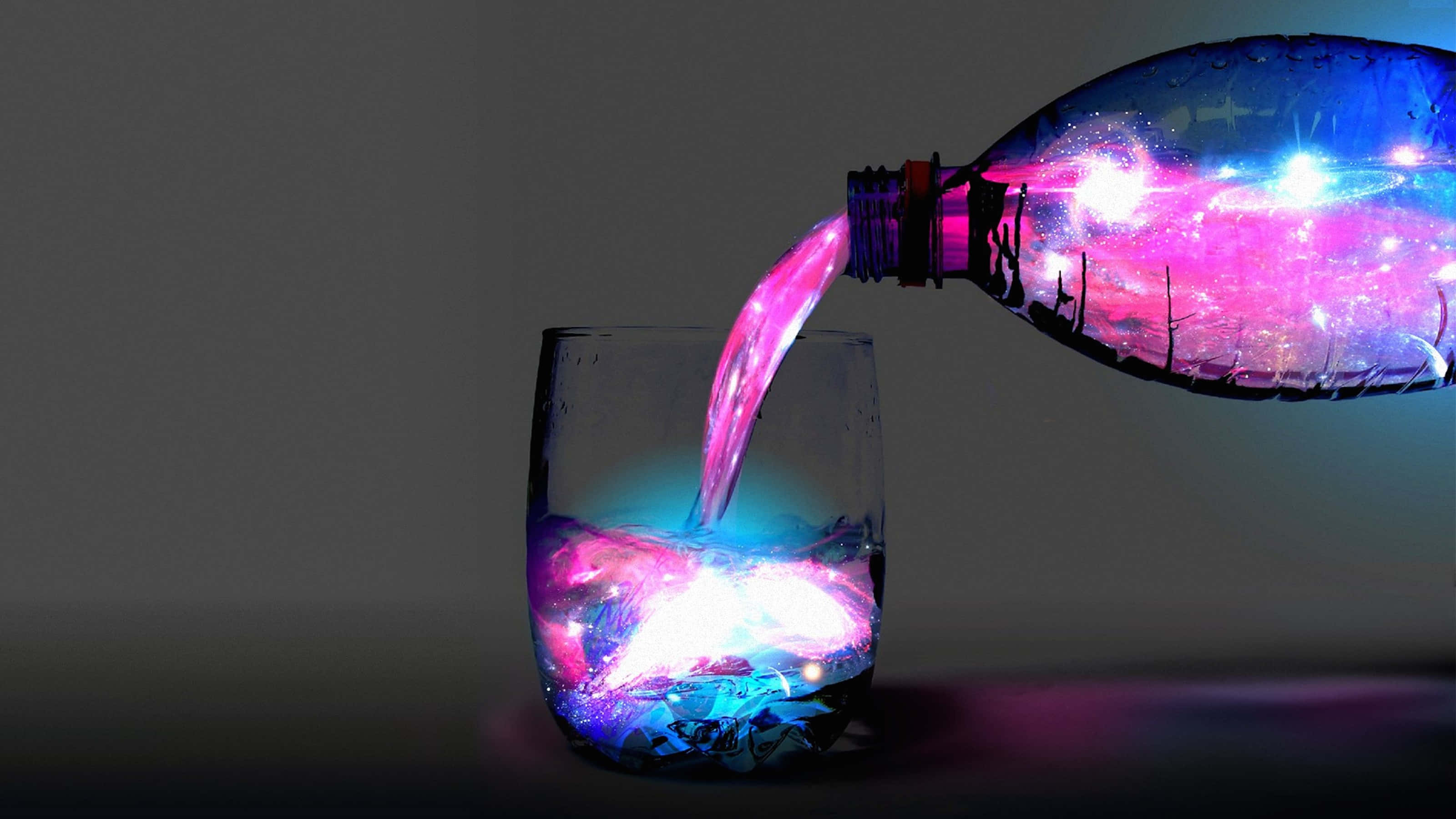 盡享酷炫 3D 美景 壁紙 — 發光的宇宙星雲從瓶子倒入玻璃杯中，背景為深色。