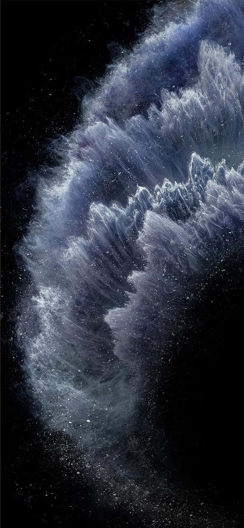 盡情享受 Apple iPhone 11 的絕美色彩 壁紙 — 一個宇宙星雲在佈滿星星的黑色虛空中以深藍色和白色旋轉，形成鋸齒狀的波浪雲。