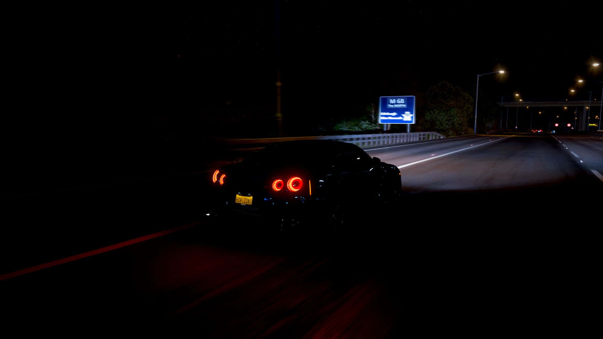 黑色跑車在夜間黑暗高速公路上疾馳，帶有發光的紅色尾燈。