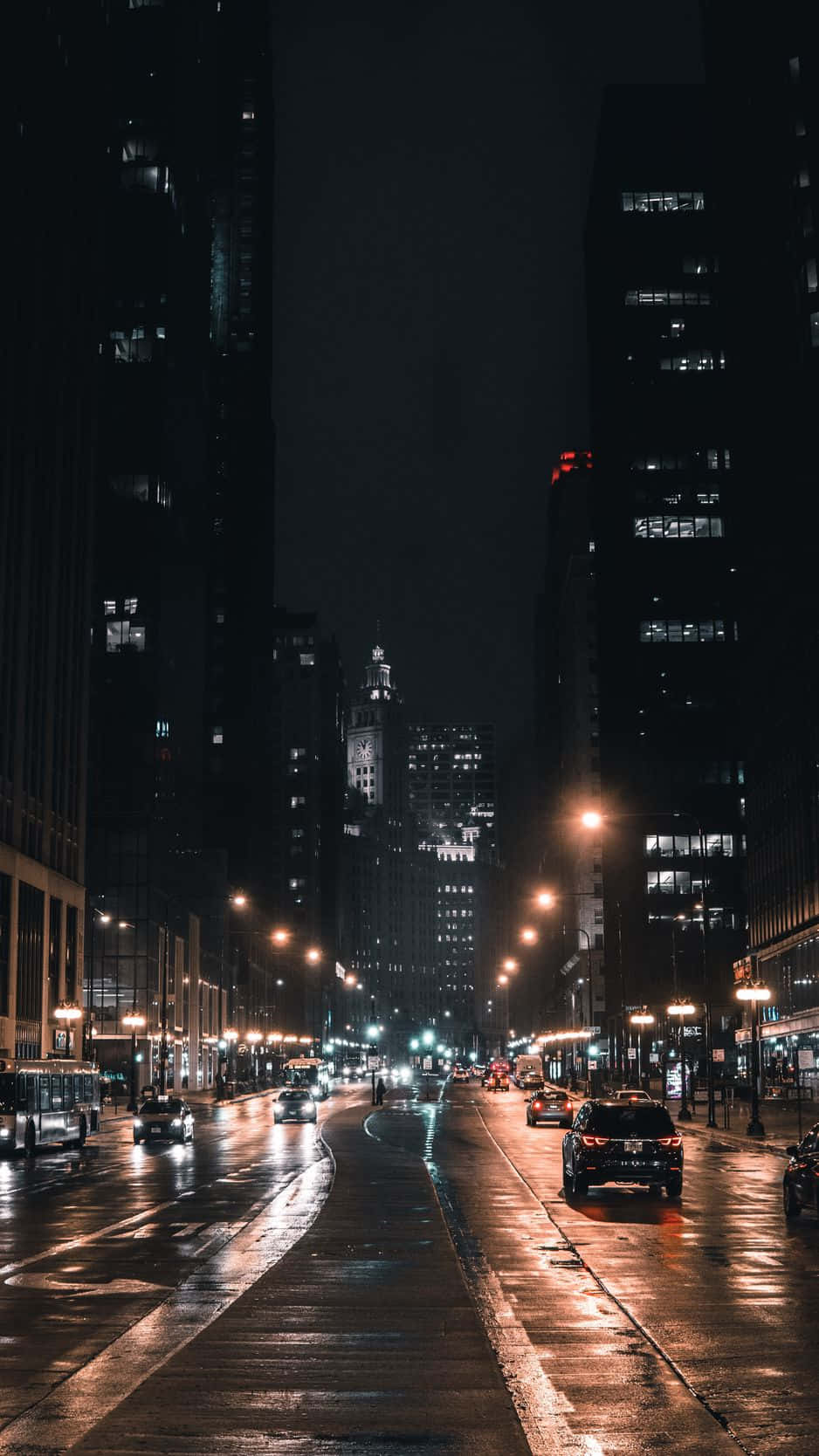 夜晚的城市街道，濕漉漉的路面反射著街燈和車頭燈。