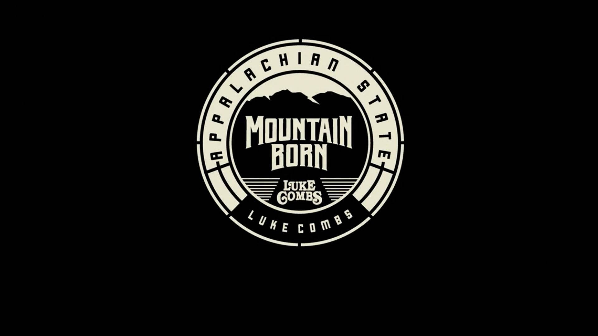 圓形標誌，帶有山脈輪廓和文字 Appalachian State Mountain Born Luke Combs，位於黑色背景上。