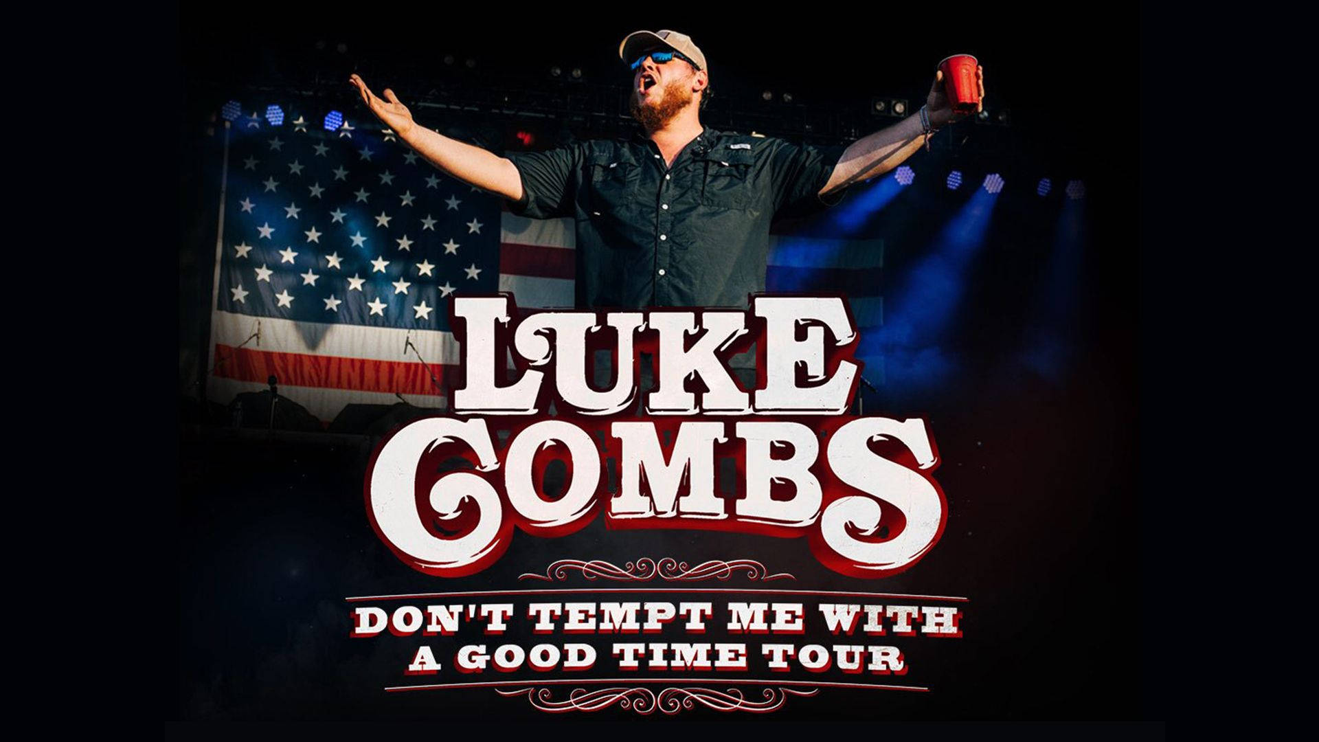 Luke Combs 在舞台上現場表演，高舉雙臂，手持紅色杯子。