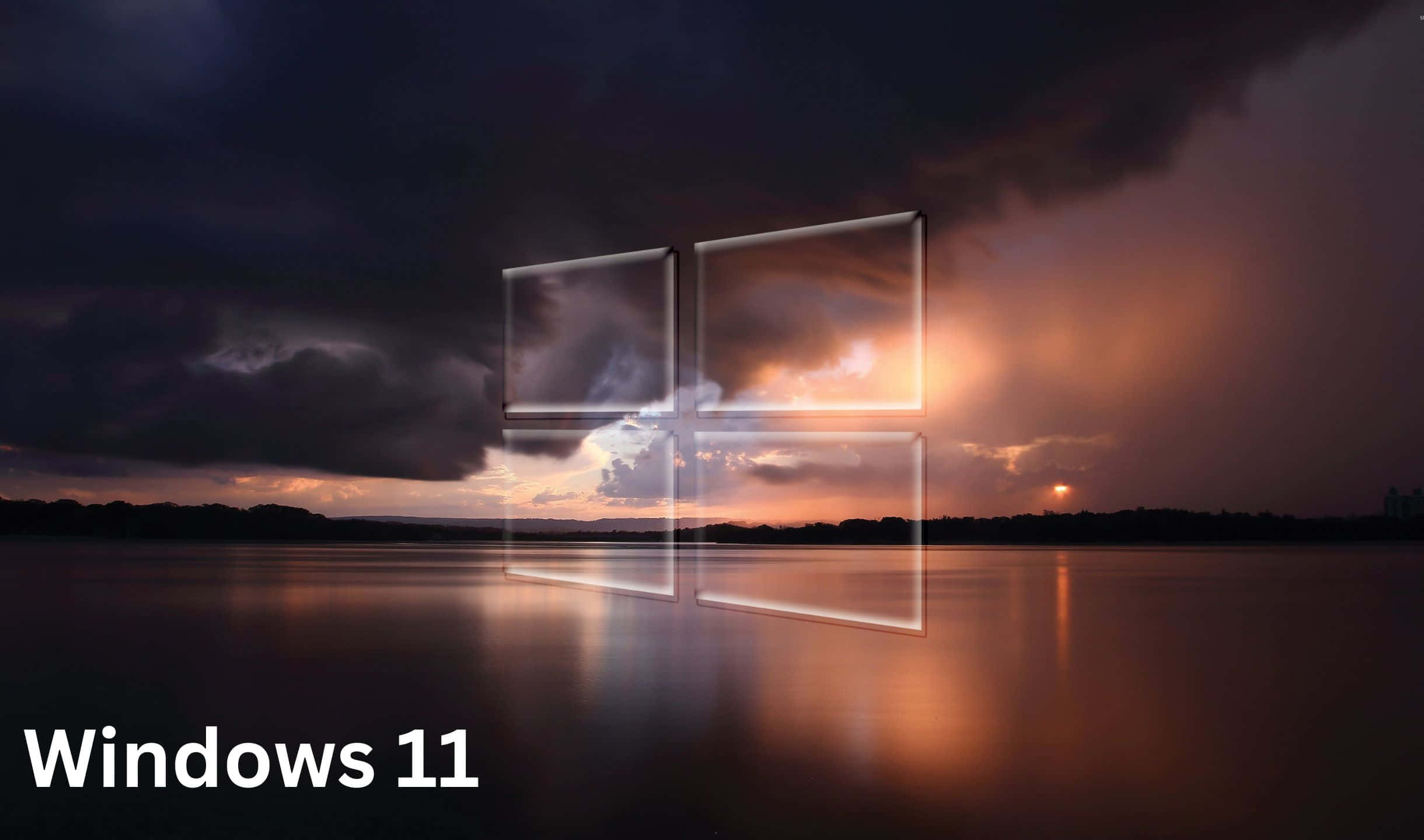 Windows 11 標誌懸浮在水面上的日落之上，帶有暴風雲。