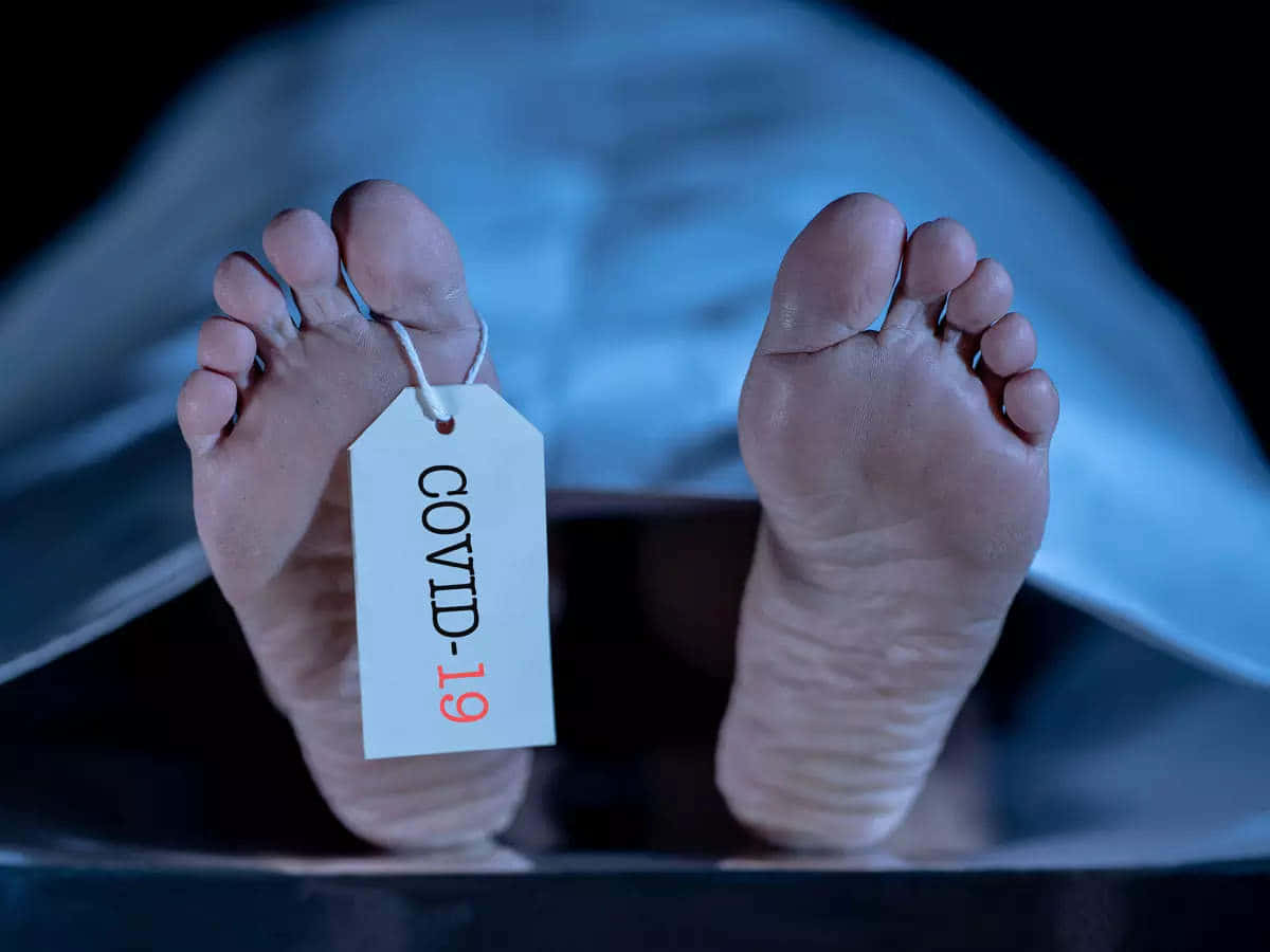 棺材內死者的腳，帶有COVID-19標籤。