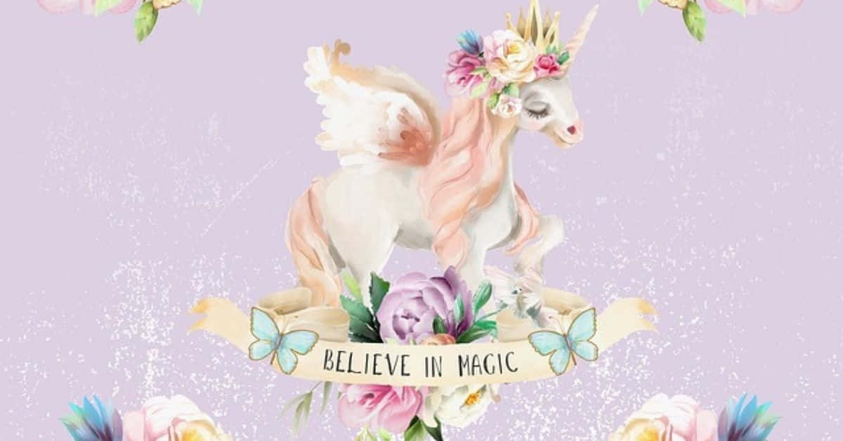 相信魔法的美麗獨角獸圖畫 壁紙 — 一隻水彩獨角獸，頭戴花冠，背有翅膀，站在寫著believe in magic的橫幅上，周圍是粉彩花朵和蝴蝶。
