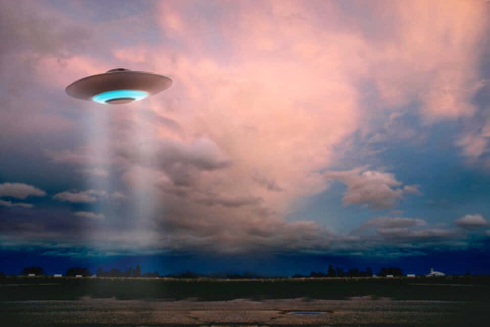 一個發光的UFO盤旋在田野上空，在黃昏時投射出光束。