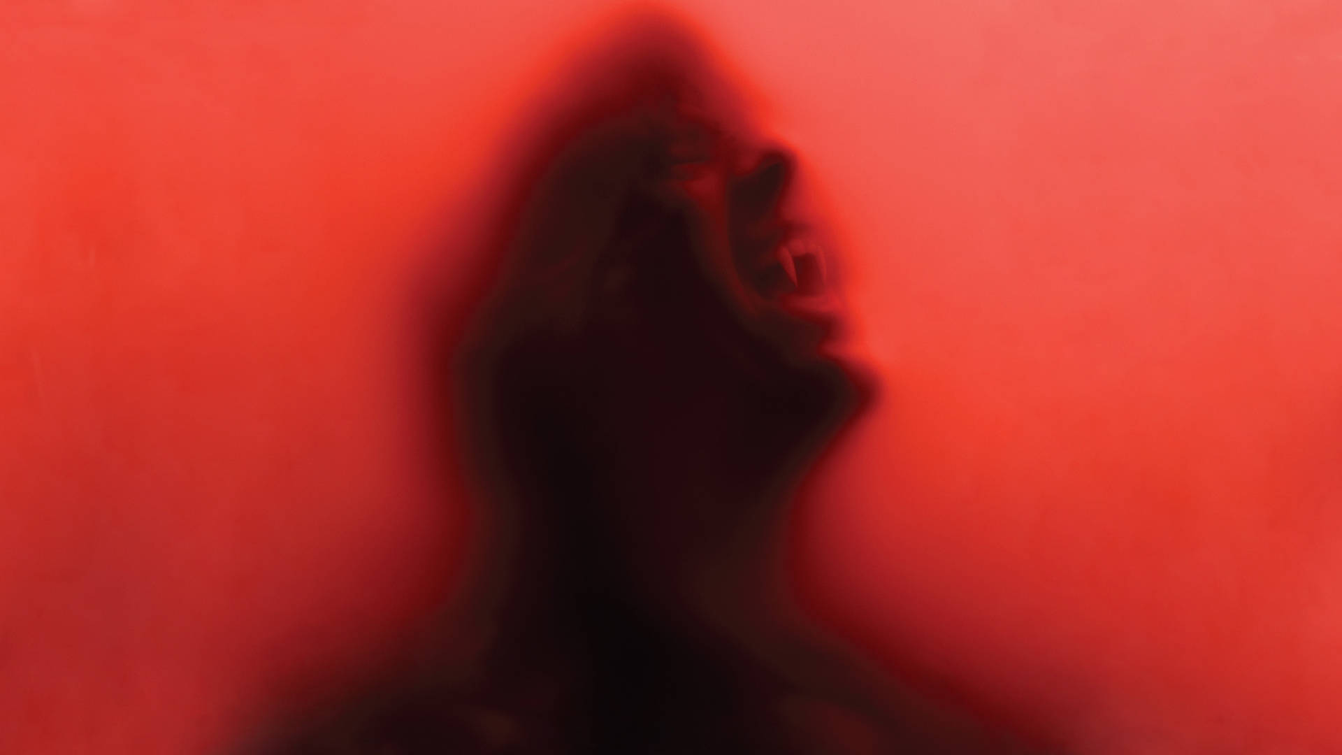《真爱如血》半透明吸血鬼 壁紙 — 一個模糊嘅尖叫人頭剪影，背景係鮮紅色。