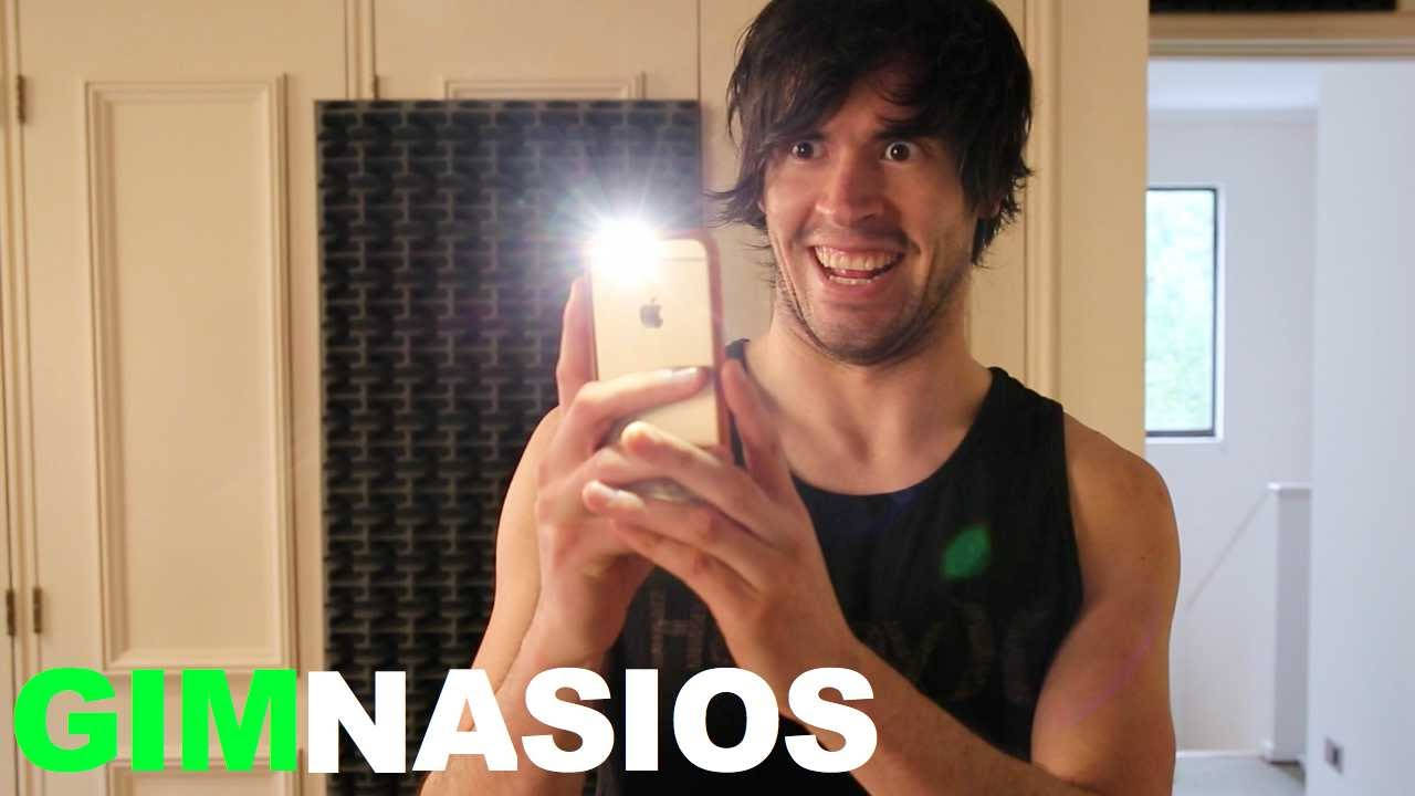 知名YouTuber HolaSoyGerman 鏡頭自拍 壁紙 — 一名黑髮、身穿黑色背心的男子，在鏡前開著手機閃光燈自拍，咧嘴大笑。