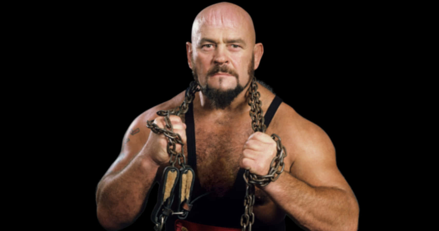 知名加拿大職業摔角手伊凡·科洛夫比賽中 壁紙 — 一個光頭肌肉發達、留鬍子的摔角手在黑色背景前緊握沉重的鐵鏈。