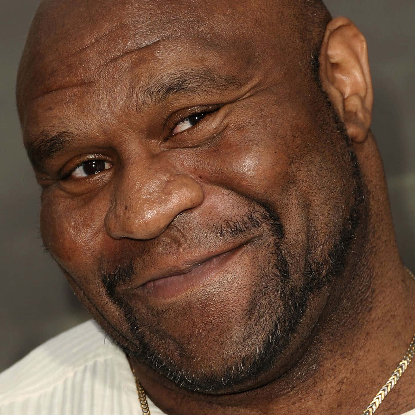 知名戰士 - Bob Sapp 高畫質肖像 壁紙 — 禿頭黑人男子嘅近距離肖像，帶住溫暖笑容同金鏈頸鏈。