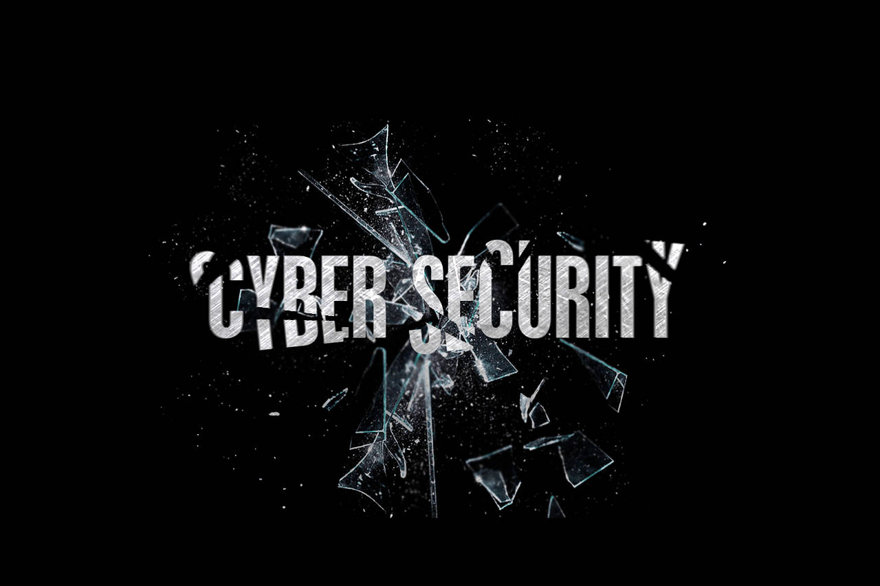 破碎的網路安全玻璃 壁紙 — 「CYBER SECURITY」一詞從破碎的玻璃中浮現，背景為純黑色。