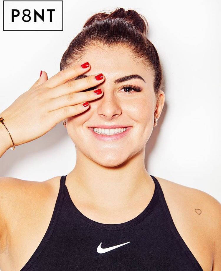 身穿黑色Nike背心的女子微笑著，一手遮住一隻眼睛。