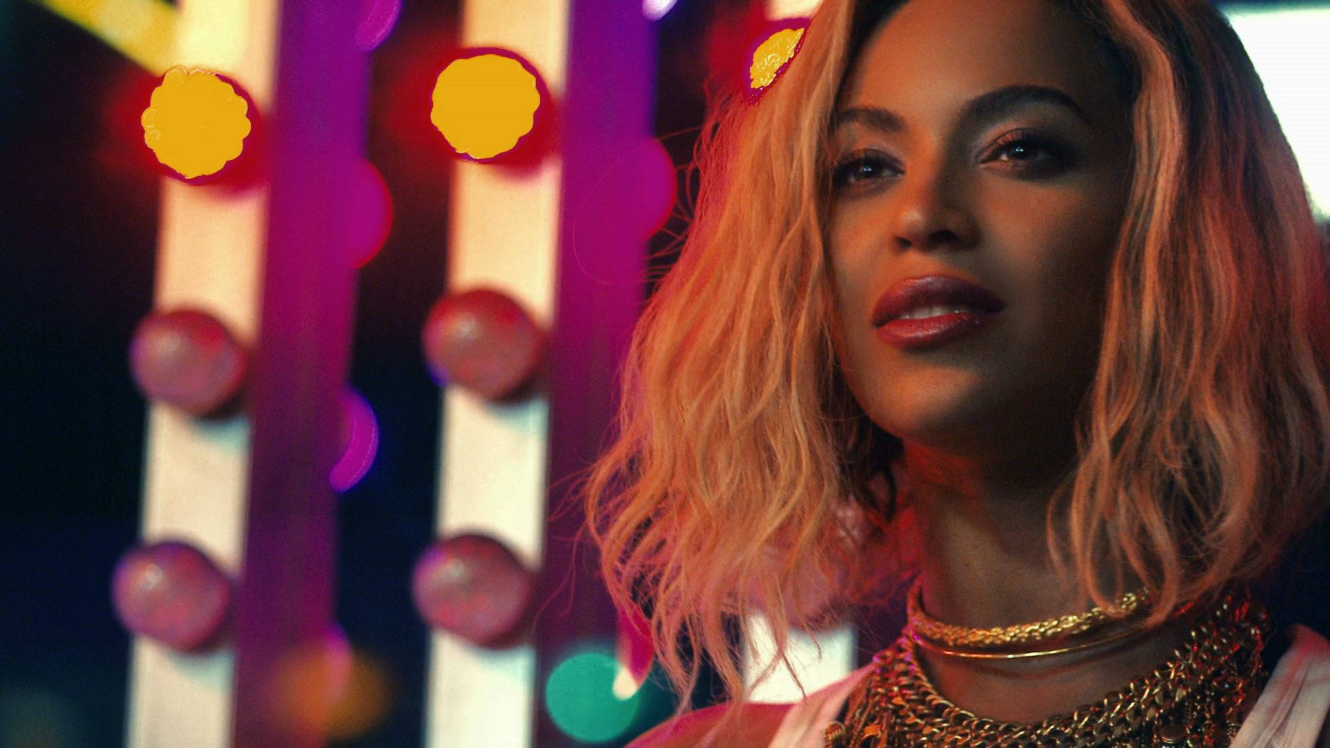 Beyoncé 在夜晚色彩繽紛的霓虹燈下佩戴華麗的金色珠寶。