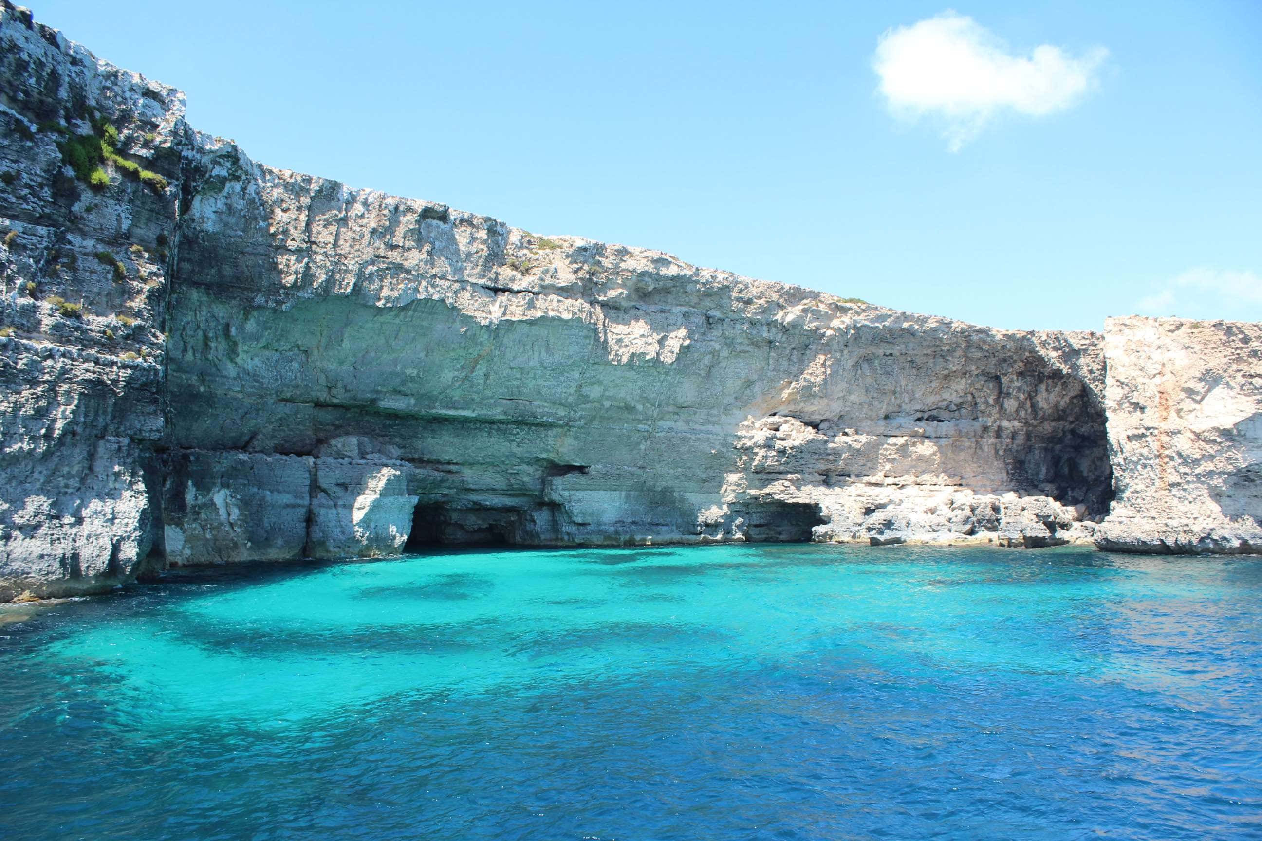 Malta 桌布 壁紙 — 碧綠色的海水拍打著高聳的白色懸崖，天空湛藍清澈，只有一朵蓬鬆的白雲。