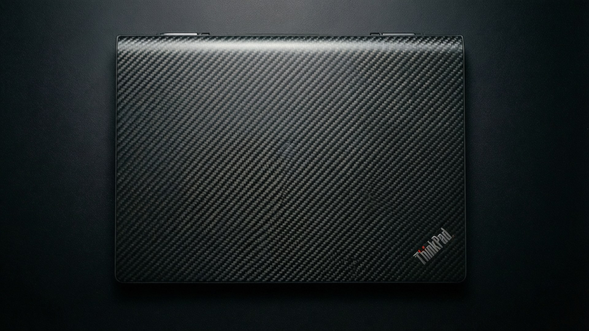 關閉的碳纖維ThinkPad筆記本電腦在深色背景上