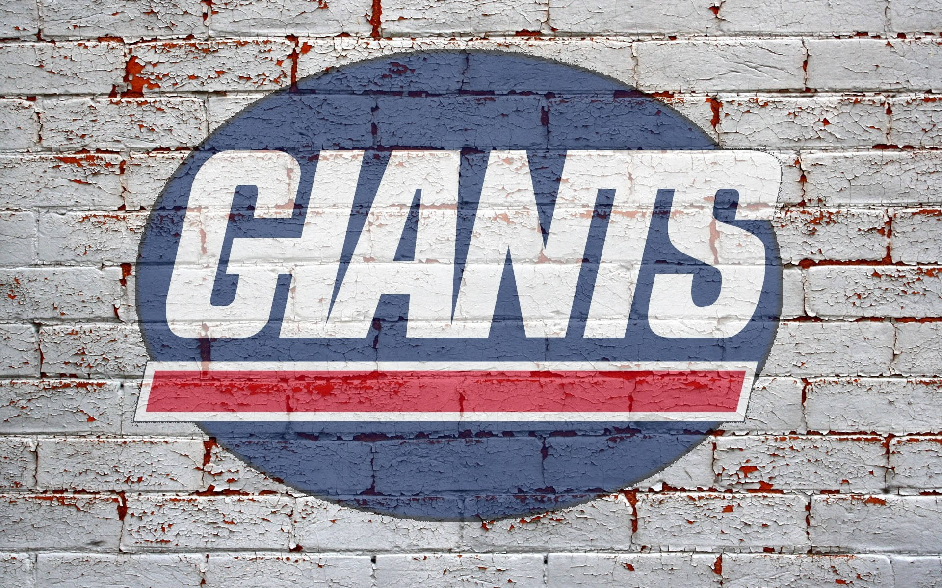 磚牆上的紐約巨人隊 壁紙 — 一個風化的「GIANTS」標誌，以粗體白色、紅色和藍色繪製在破裂、剝落的白色磚牆上。