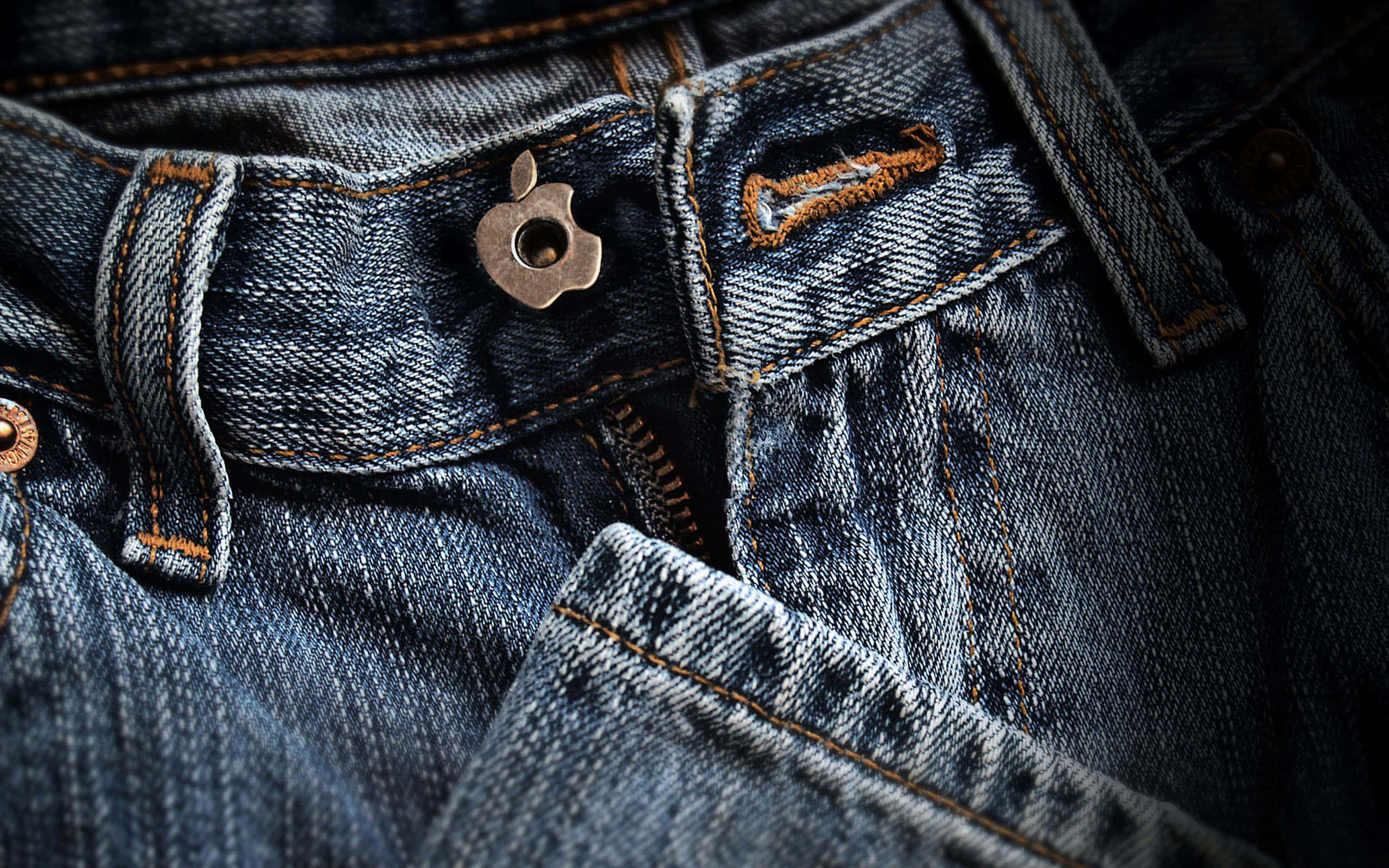 Denim 桌布 壁紙 — 磨損嘅藍色牛仔褲近鏡，帶有金屬蘋果鈕扣同橙色縫線。