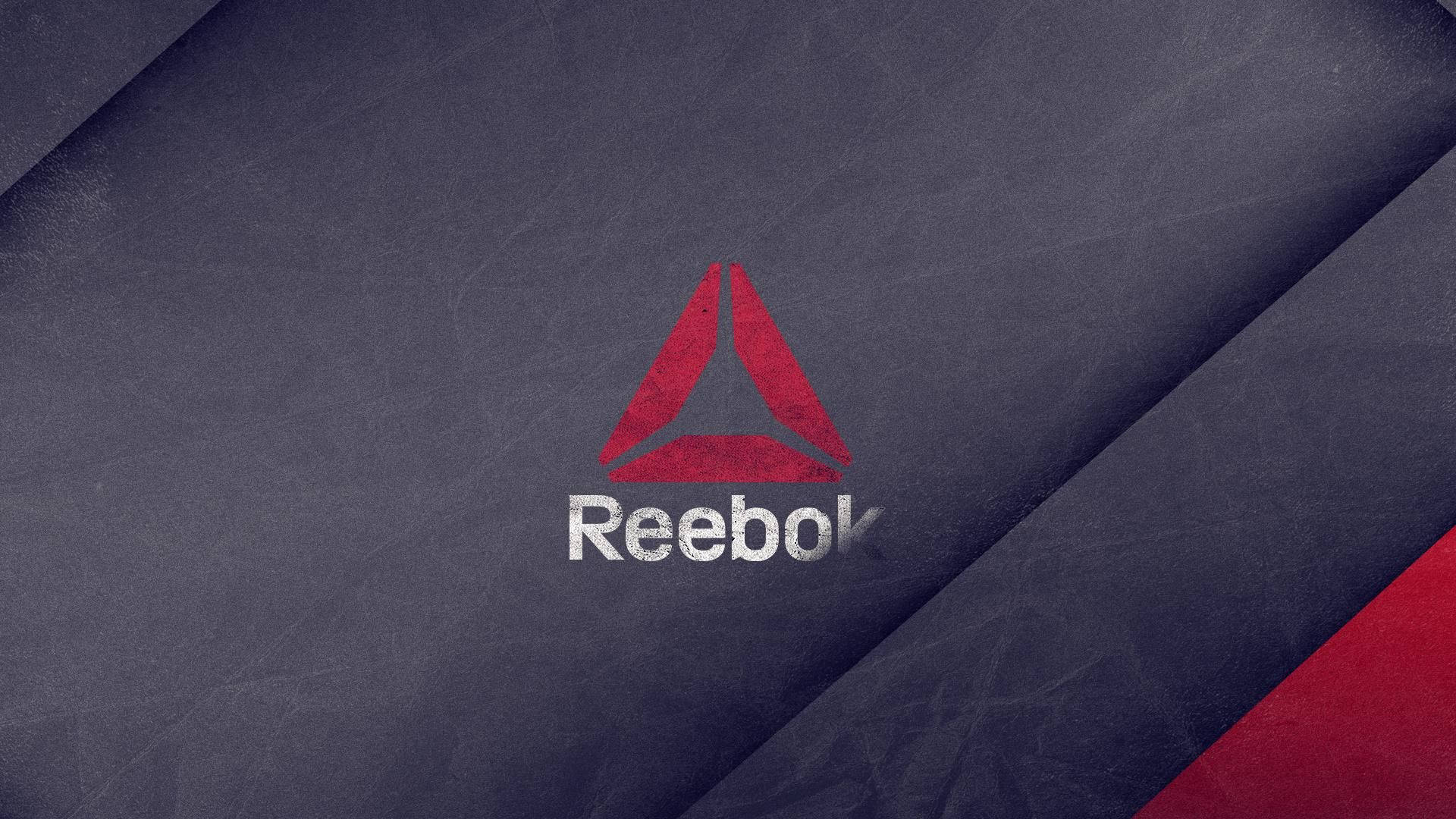 Reebok 標誌位於有紋理的深藍色布料上，帶有紅色對角線條紋。