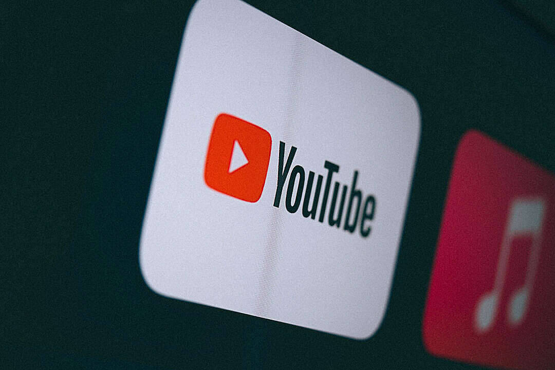 YouTube應用程式圖示在黑暗屏幕上發光，旁邊有一個音樂應用程式圖示。