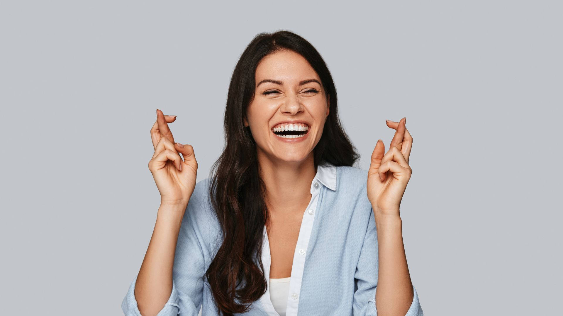 女性交叉手指笑著希望好運。