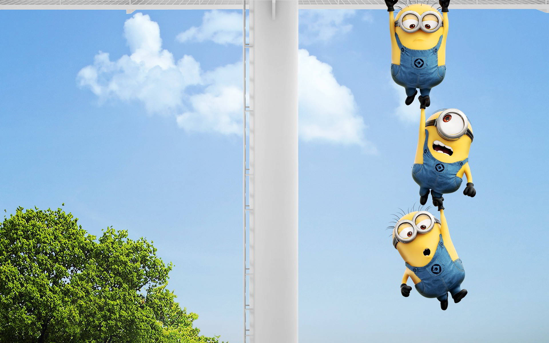 三個卡通Minions倒掛在戶外的桿子上。