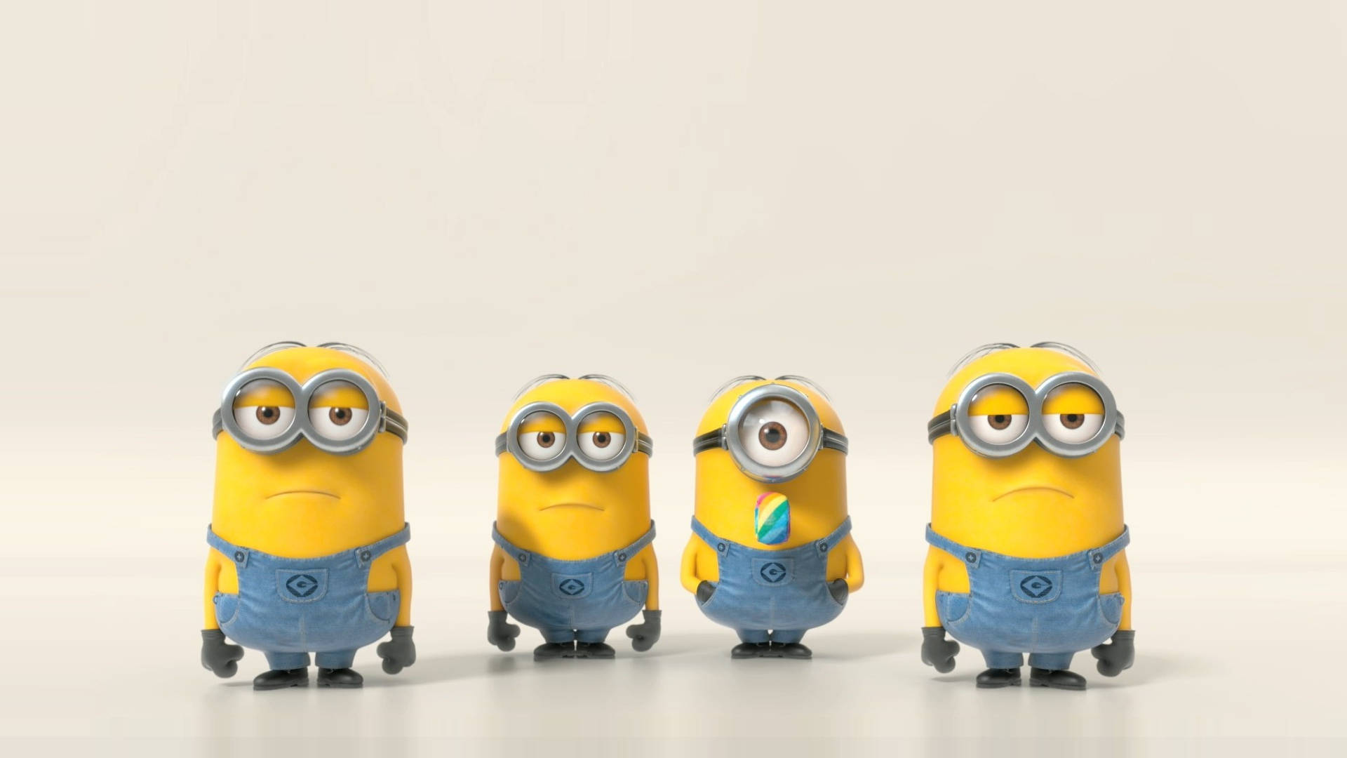 四個黃色卡通Minions身穿藍色工裝褲排成一排。