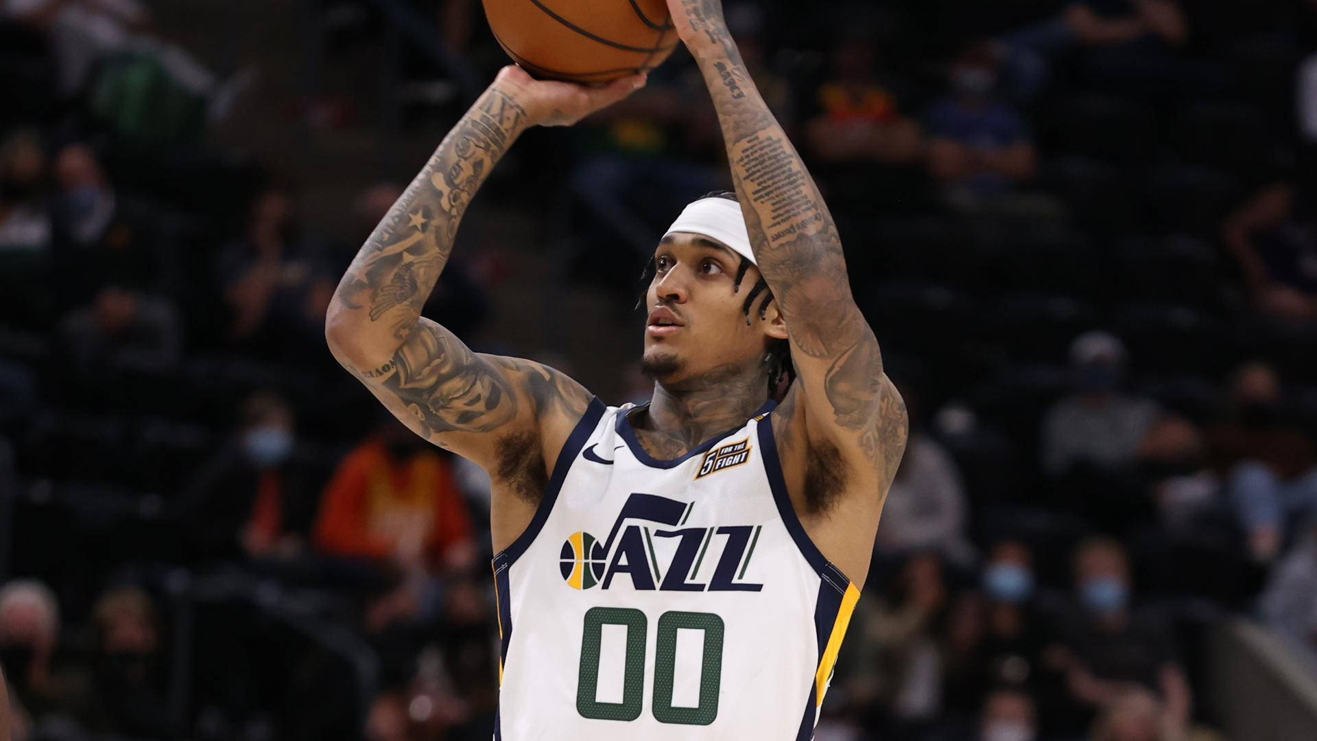 神射手Jordan Clarkson 壁紙 — 一位身穿白色爵士隊球衣、背號00的籃球運動員，雙手高舉準備投籃。