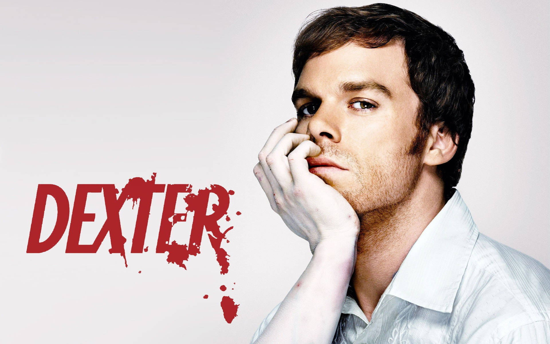 穿著白恤衫嘅男人，喺有紅色濺墨嘅「Dexter」文字旁邊，表情嚴肅。
