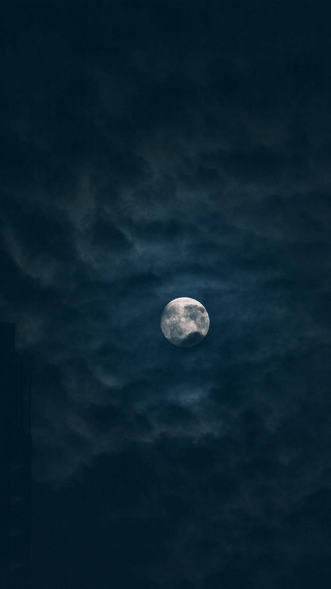 滿月在夜空中的烏雲間閃耀。