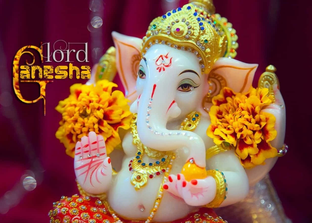 神聖優雅：象頭神 Ganesha 的莊嚴風采 壁紙 — 一尊閃耀的白色象神像，飾以金色珠寶和鮮黃色萬壽菊，背景為深紅色。