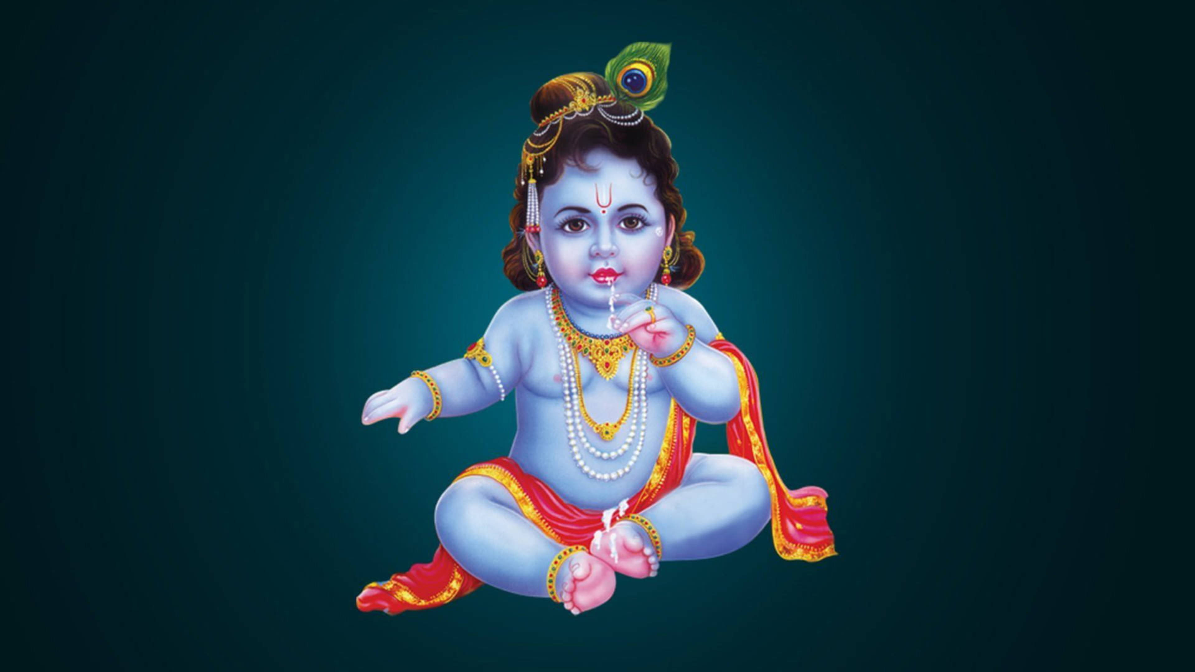 krishna ji 桌布 壁紙 — 神聖的藍皮膚嬰兒克里希納盤腿而坐，飾有黃金珠寶和孔雀羽毛皇冠，背景為深藍綠色漸變。