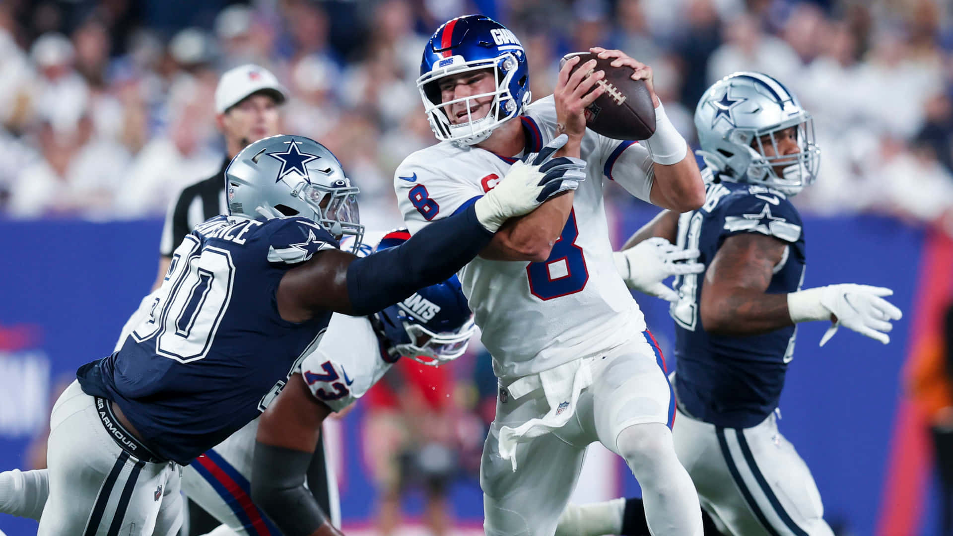 NFL四分衛在現場比賽中受到兩名防守球員的壓力。