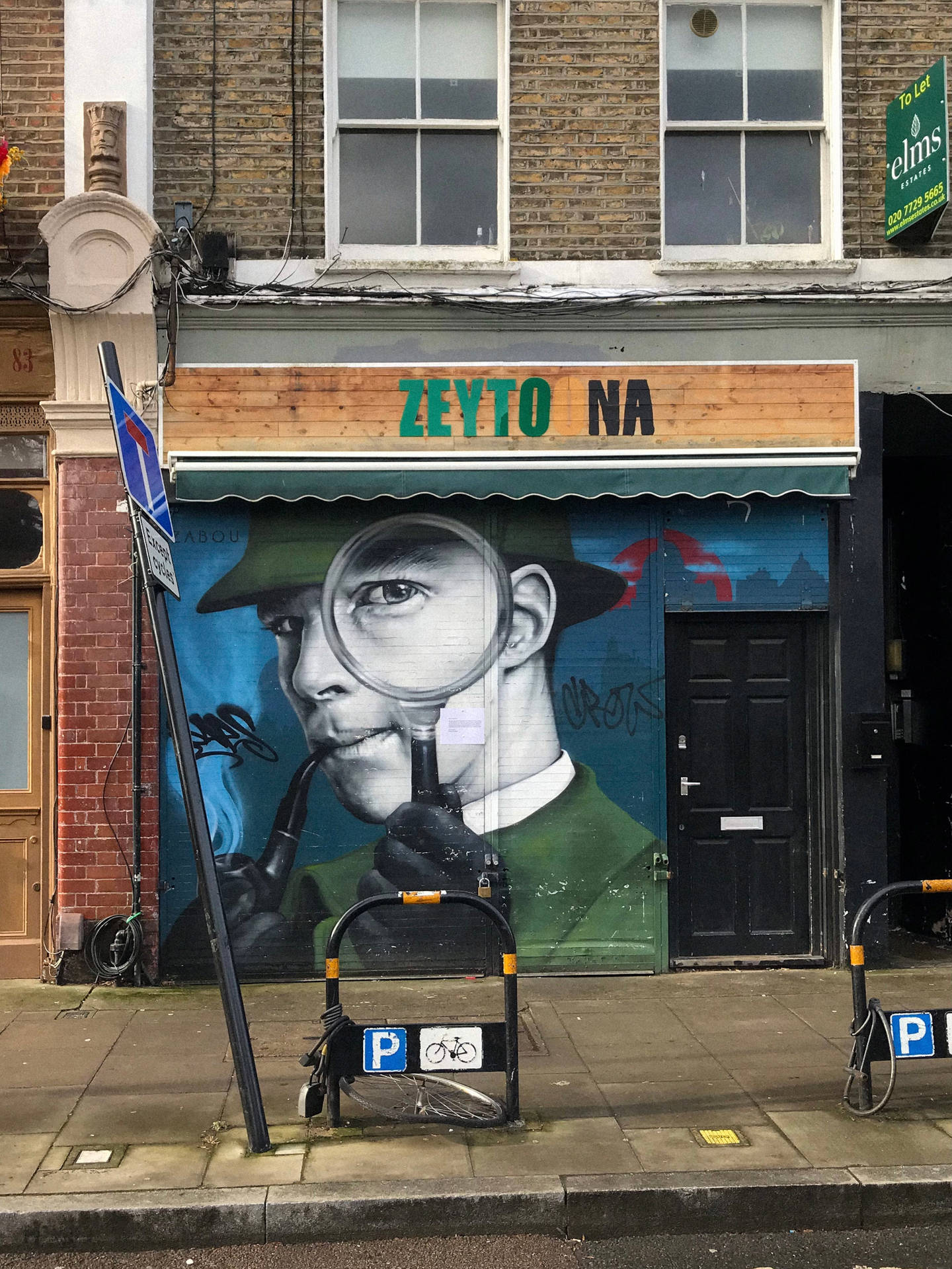 偵探壁畫，帶放大鏡和煙斗，位於城市商店門上。