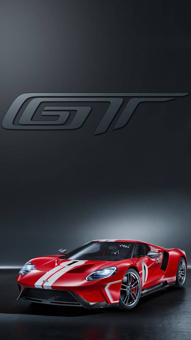 福特 GT iPhone 背景 壁紙 — 一輛引人注目的紅色福特GT跑車，帶有白色賽車條紋，在戲劇性的工作室燈光下，以深灰色背景和大型GT標誌展示。