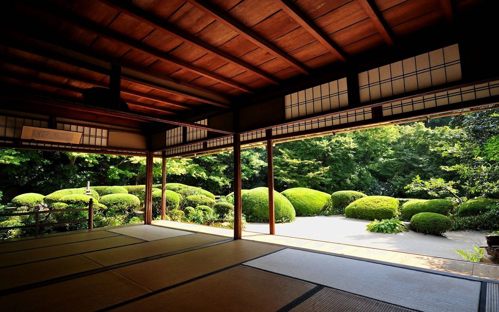 禪修禪寺 壁紙 — 傳統日式木造陽台俯瞰著一個寧靜的花園，園內有修剪整齊的綠色灌木和一條沐浴在柔和陽光下的碎石小徑。