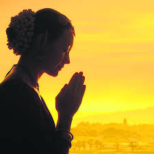 金色夕陽下祈禱女子剪影