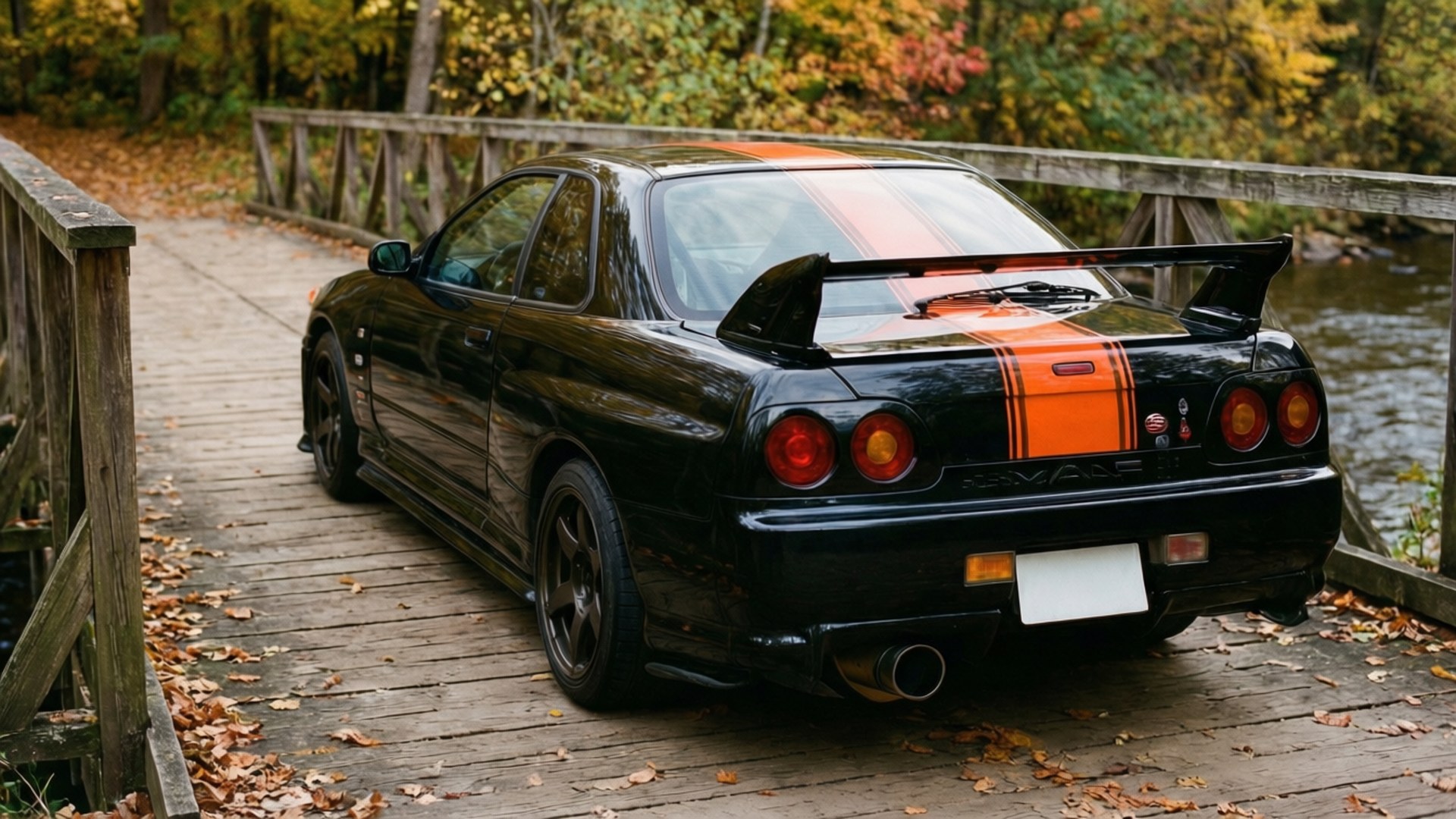 黑色日產Skyline R34帶橙色條紋停泊在秋林中的木橋上。
