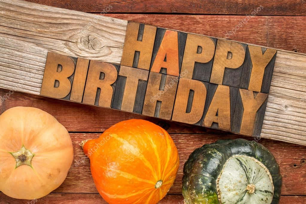 木製字母的 happy birthday 文字，木頭表面上有南瓜。