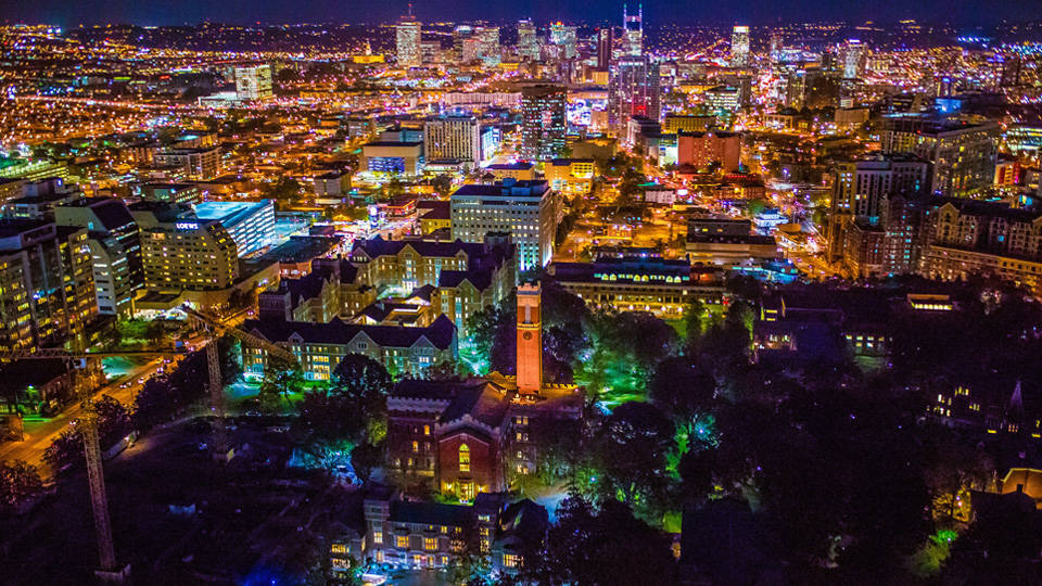 夜晚鳥瞰燈火通明的城市，建築物和街道閃閃發光。