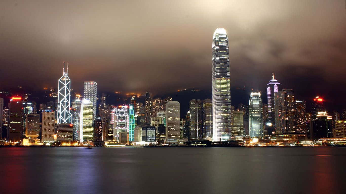 香港城市夜景，發光的摩天大樓倒映在水中。