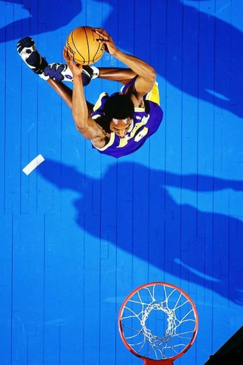 籃球運動員在半空中於藍色球場上灌籃。
